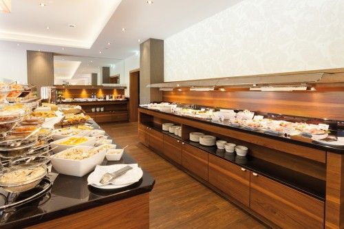 Elegantes Frühstücksbuffet in einem modernen Speiseraum mit einer Vielzahl von Speisen und Geschirr.